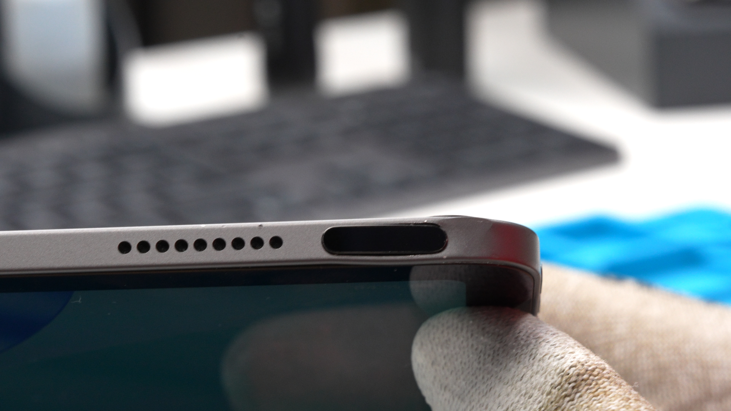 Detailaufnahme eines Tablets in der Werkstatt: Der Powerbutton ist nach einem Sturz oder Schlag sichtlich beschädigt und eingedrückt, was eine Reparatur erforderlich macht.